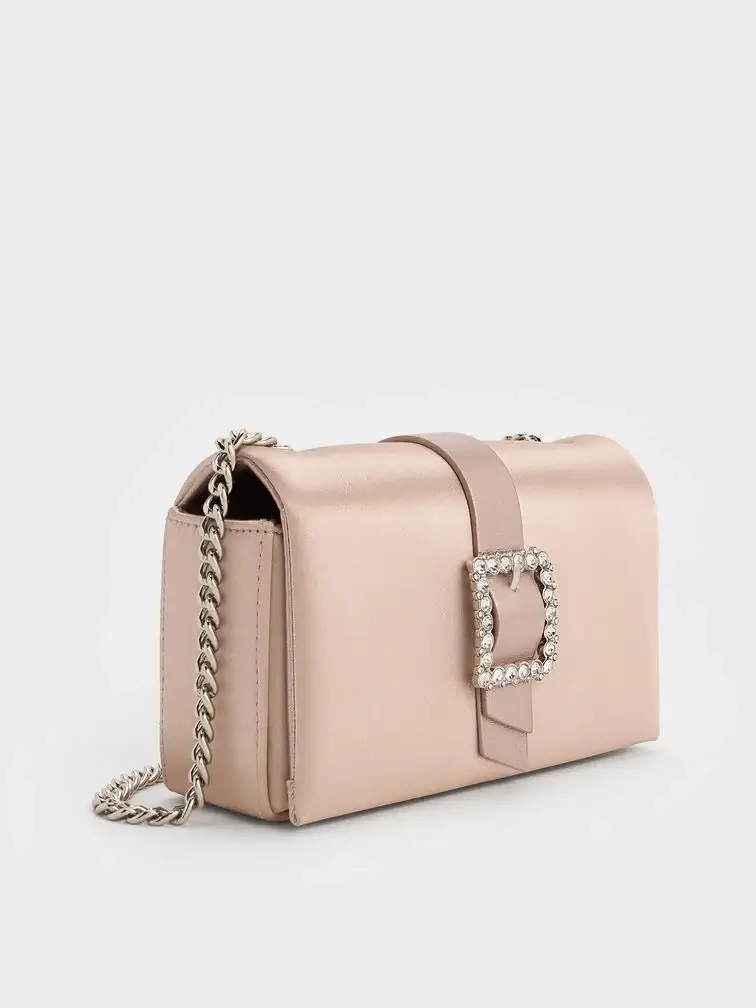 Satin clutch in blush with a crystal buckle, ideal for formal weddings or evening celebrations.