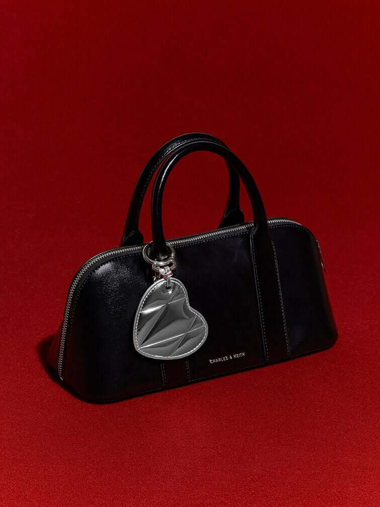 This quilted silver heart charm can add a playful touch to a black top-handle bag.  