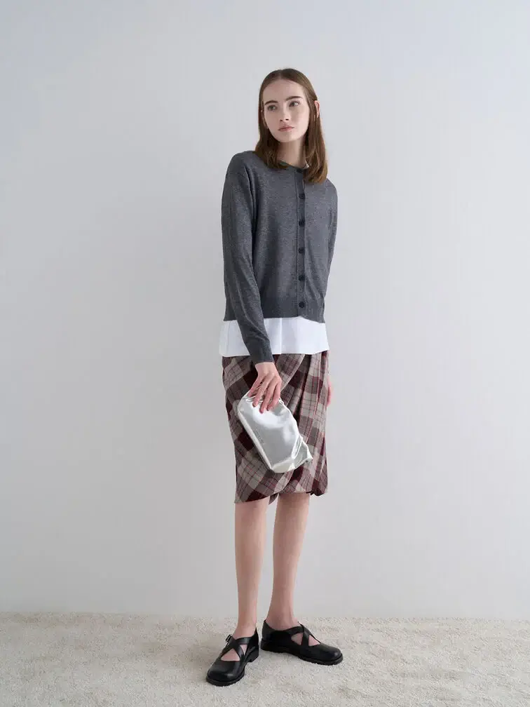 Clutch held vertically from the side with the thumb at the back, offering an unconventional way to carry smaller bags.