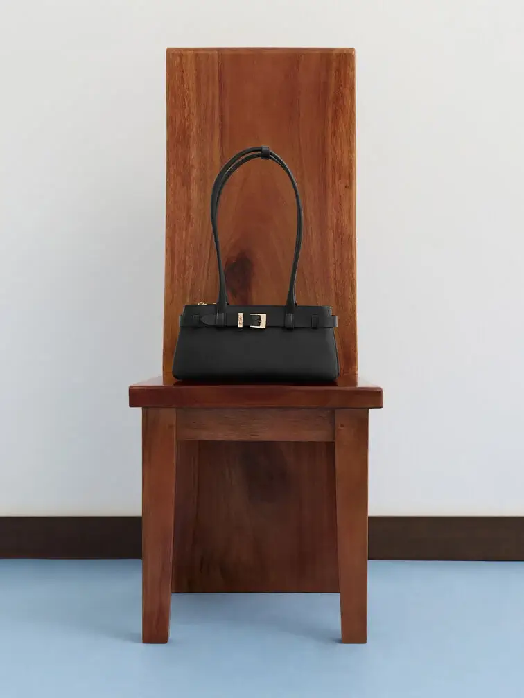 Black East-West bag with a belted detail and long shoulder straps.  