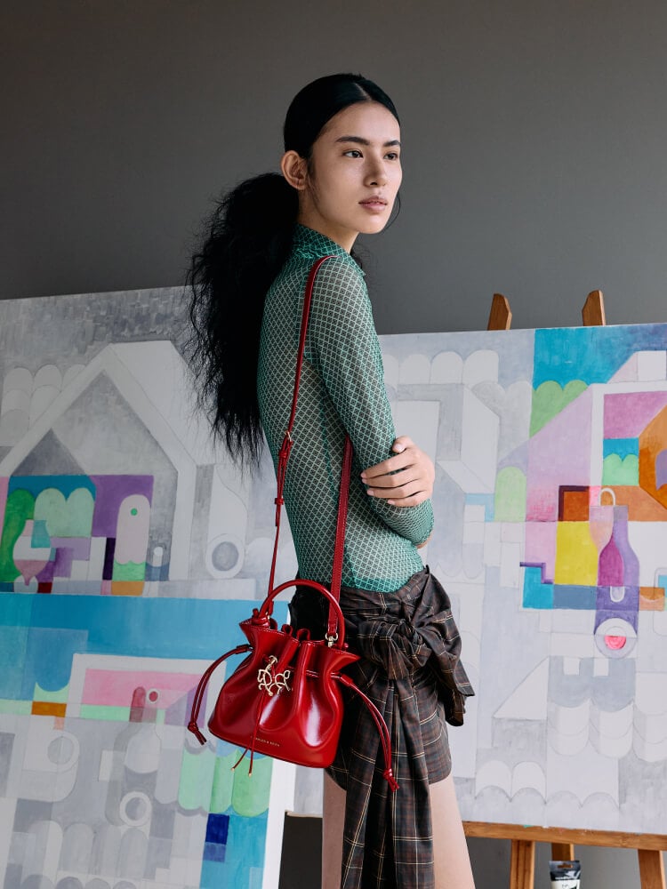 Women’s Sammie horse-motif drawstring bucket bag in tomato red - CHARLES & KEITH