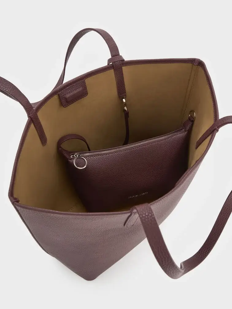 The Beryl tote features a spacious main compartment and comes with a generously sized detachable pouch. 