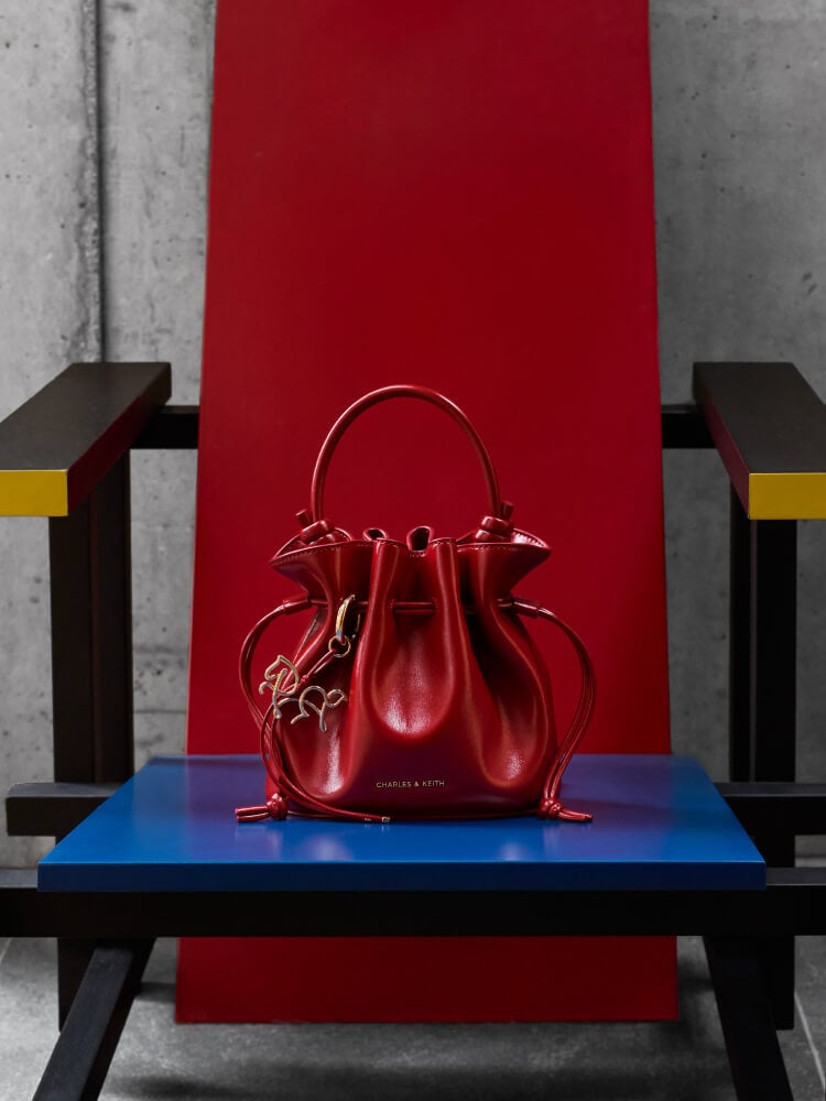 Women’s Sammie horse-motif drawstring bucket bag in tomato - CHARLES & KEITH