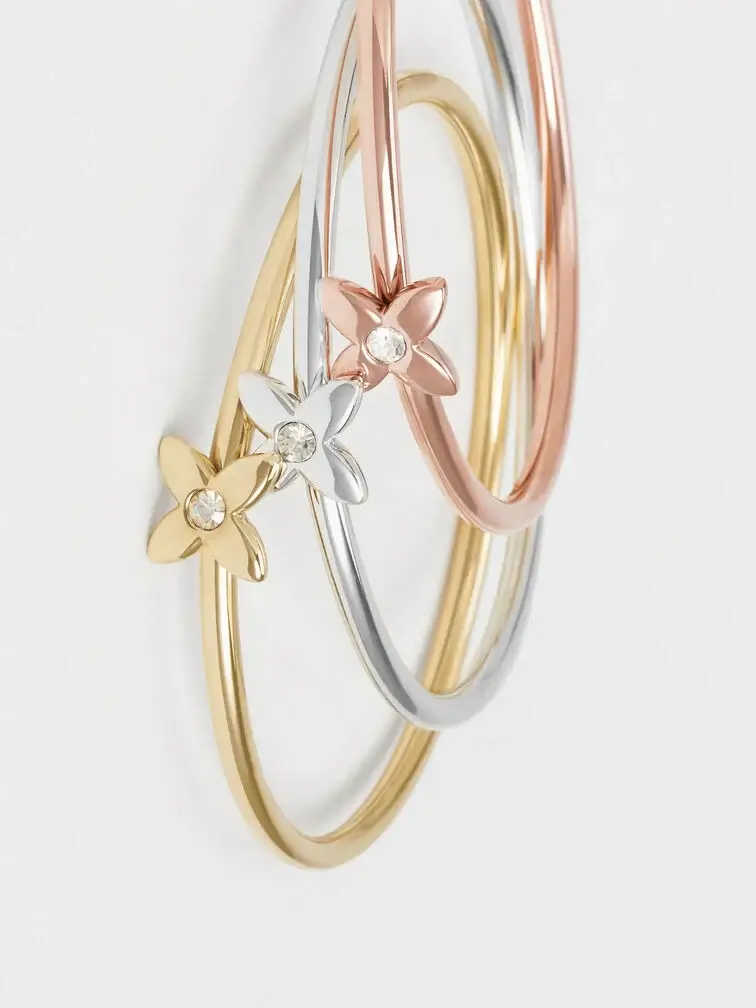 Gold, rose gold and silver flower-motif crystal bangle, a timeless and sentimental gift to give your mum this Christmas. 