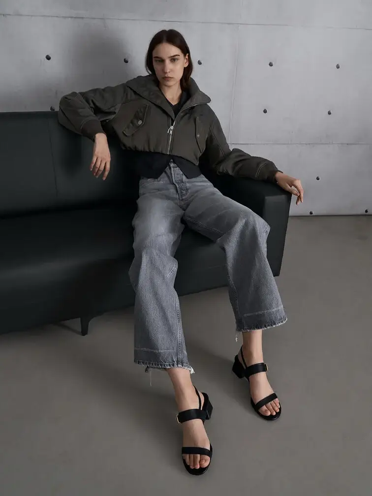 Frayed wide-leg jeans pair perfectly with black block-heel sandals for a casual and laid-back look.